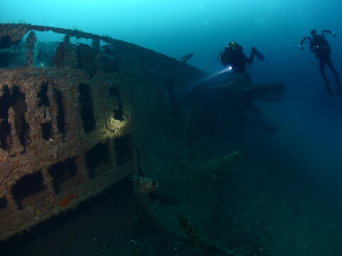 scuba divers taking photos and exploring  u boat wreck ww2 submarine