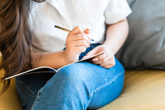 Close up view of a woman writing in a notebook.