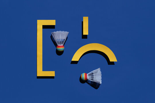 Two badminton shuttlecocks with geometric details on blue background