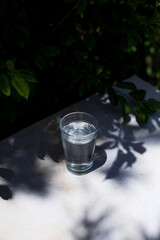 glass full of mineral water on a table on a sunny day. healthy beverage concept