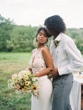 Portrait of a groom kissing his bride sensually on her temple