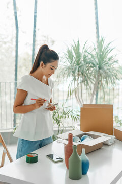 Focused mature saleswoman recounting all goods at decor store