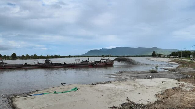 dredging boat adding large quantities of sand to increase riverbank width