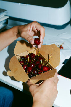 man in the office eating cherries