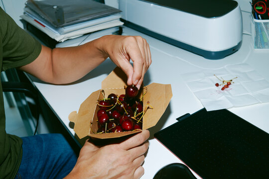 man eating cherries in the office
