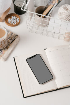 Diary and phone with coffee cup and stationery on desk