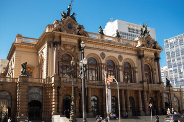The main entrance of the Municipal Theatre of São Paulo with a stunning blue sky , historic center...