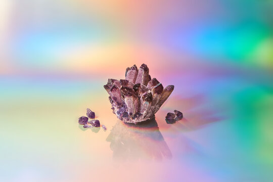 Shiny amethyst crystal on multicolor background