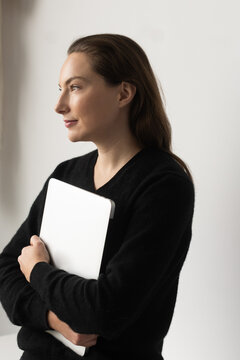 Young woman smiling and holding laptop