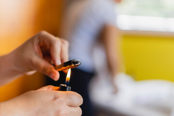 Unknown lighting a piece of Palo Santo. 