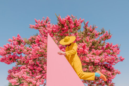 Faceless man poses with triangle