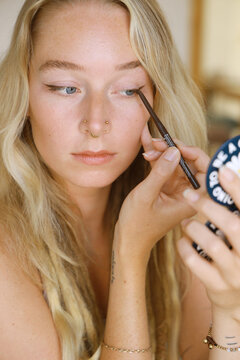 young woman applying make-up