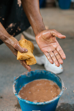 Anonymous person washing hands with sponge