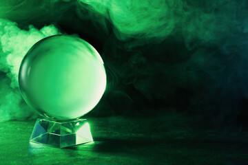 Crystal ball on table and smoke against dark background, space for text. Predictions of future