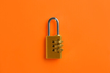 Modern combination lock on orange background, top view