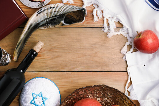 Frame of Rosh Hashanah holiday attributes on wooden table, flat lay. Space for text