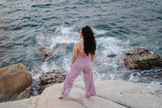 Portrait of a young Latina woman enjoying the view of the sea.