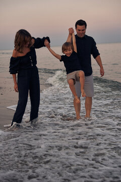 family playing along the shoreline