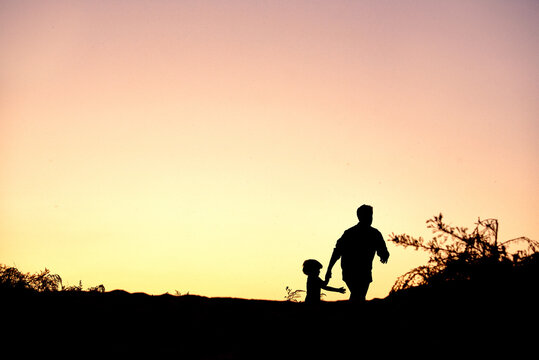 silhouette of a dad with a child outdoors