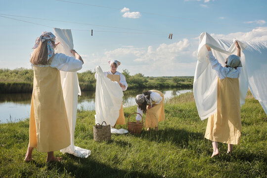 Women Hanging Linen On Clotheslines