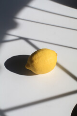 Fresh ripe lemons citrus fruit on white under sunlight from window. Art minimal composition. Juicy lemon.