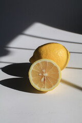 Fresh ripe lemons citrus fruit on white under sunlight from window. Art minimal composition. Juicy lemon.