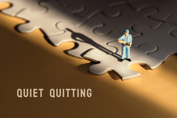 Concept of quiet quitting, job burnout, depression. Single tiny worker miniature figure on edge of...