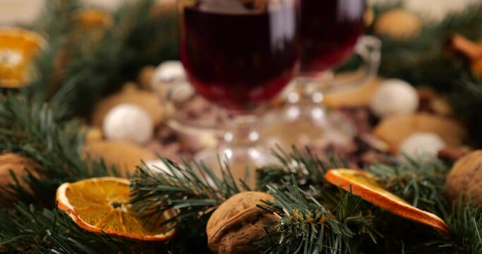 Festive composition on the theme of Christmas with mulled wine, a wreath of coniferous branches and orange slices and sweets.