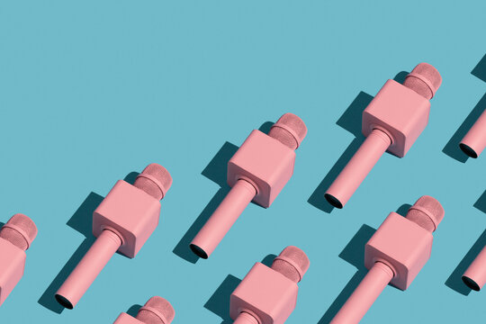 Pink microphones on blue background. Repetition pattern.