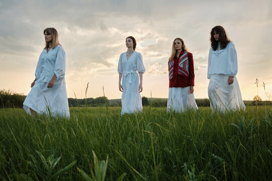 Group Of Women Walking Along Meadow