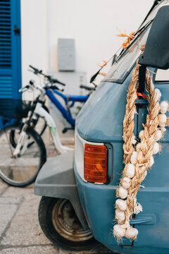 Front of a mobile greengrocer with garlic around wing mirror