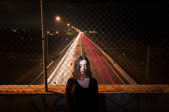Night portrait of woman on highway bridge