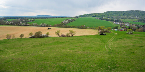 Fototapeta na wymiar Green meadows, fields, spring forests and Russian tanks.