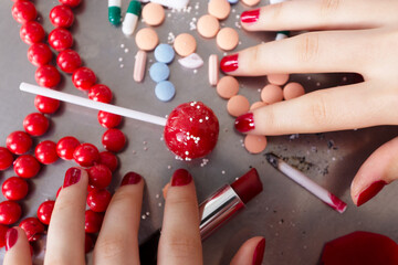 Hands of anonymous woman next to metal tray full of addictive elements