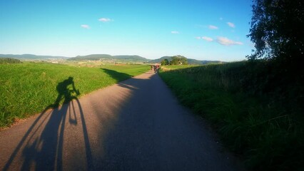 Shadow of cyclist training on group ride at sunset