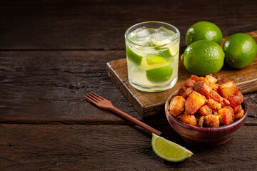 Pork rinds (torresmo) with caipirinha, typical Brazilian food.