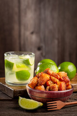 Pork rinds (torresmo) with caipirinha, typical Brazilian food.