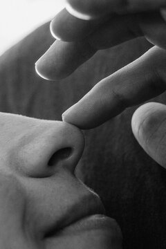 Close up photo of finger touching female cum nose

