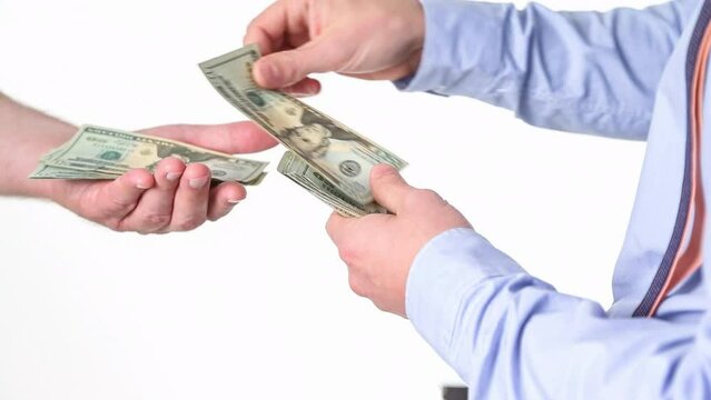 One man paying another person cash, counting 100 dollar bills into his hand