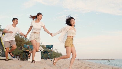 Happy friends holding hands running enjoy life funny and freedom on sand at beach together to sea...