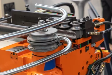 Foto op Plexiglas Hydraulic pipe bender bends round stainless steel pipe. Pipe bending machine in a factory. Bent steel © hodim
