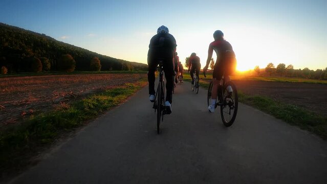 Friends riding on bike trail at sunset. Cycling