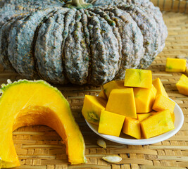 Asian pumpkin, rough exterior Sliced yellow pumpkin flesh is ready to be used as an ingredient in cooking and dessert.