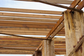 A wooden frame structure with massive supporting pillars prepares the construction of a two-story house.