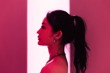 Profile portrait of an Asian woman with neon light