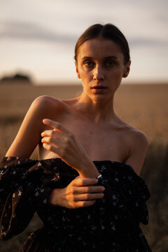 Girl in feminine garment adjusting her jewellery 