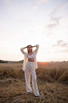 Woman in elegant garment passing time near grassland 