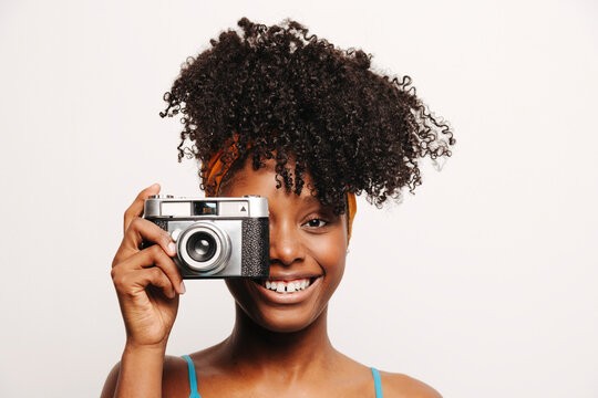 Smiling black woman with vintage photo camera