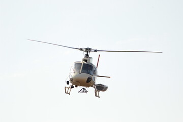 Fototapeta na wymiar Helicoptero volando con vidrios oscuros y cielo blanco