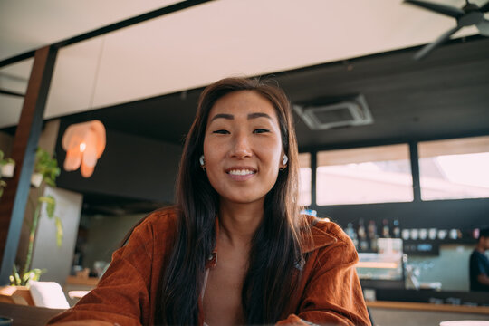 Asian Woman Listening And Looking At Webcam On Laptop